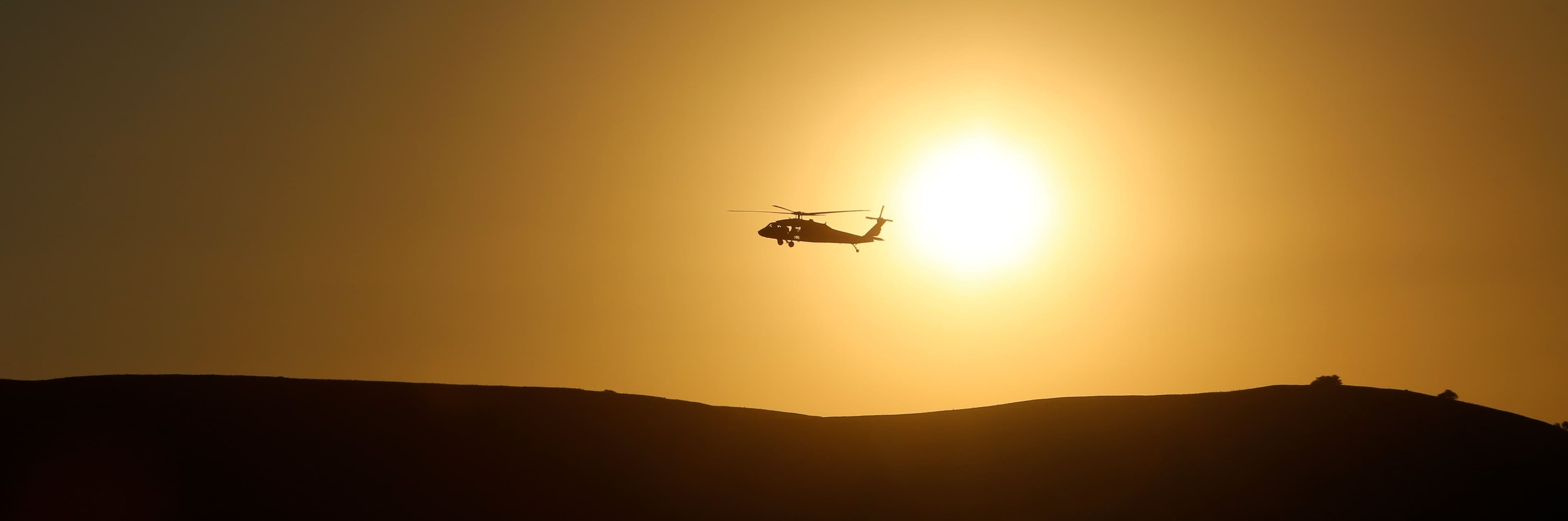 helicopter flying in sunset